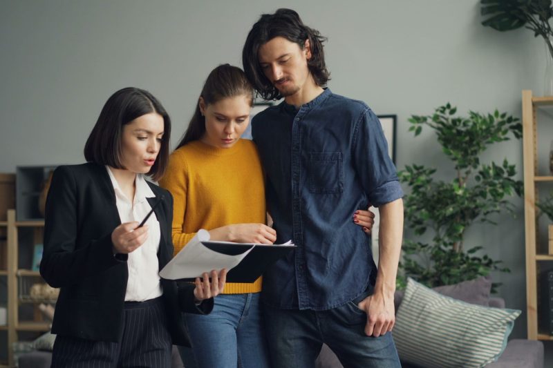 Home 9 A couple reviewing documents with a real estate agent indoor 1781629493